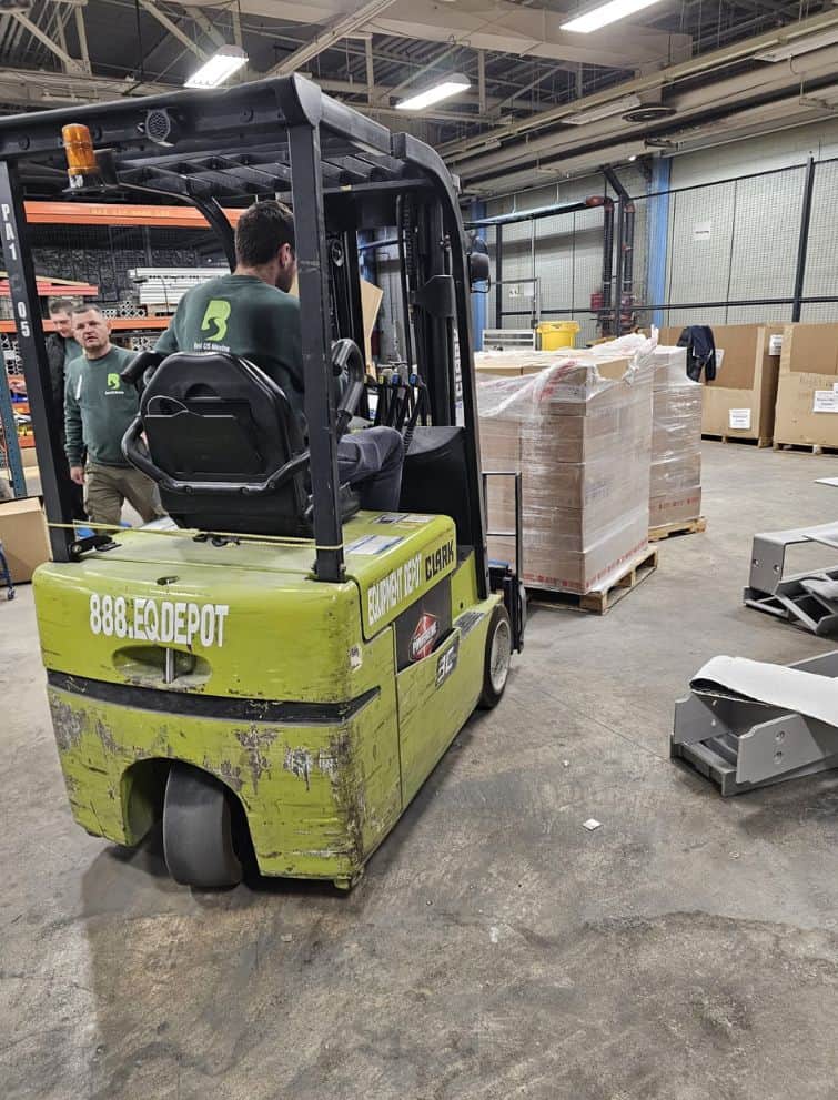 Moving equipment and workers preparing for a local move at a warehouse.