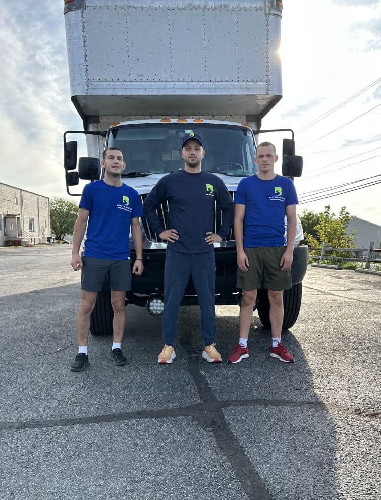 Professional moving team standing in front of a moving truck for US relocation services.