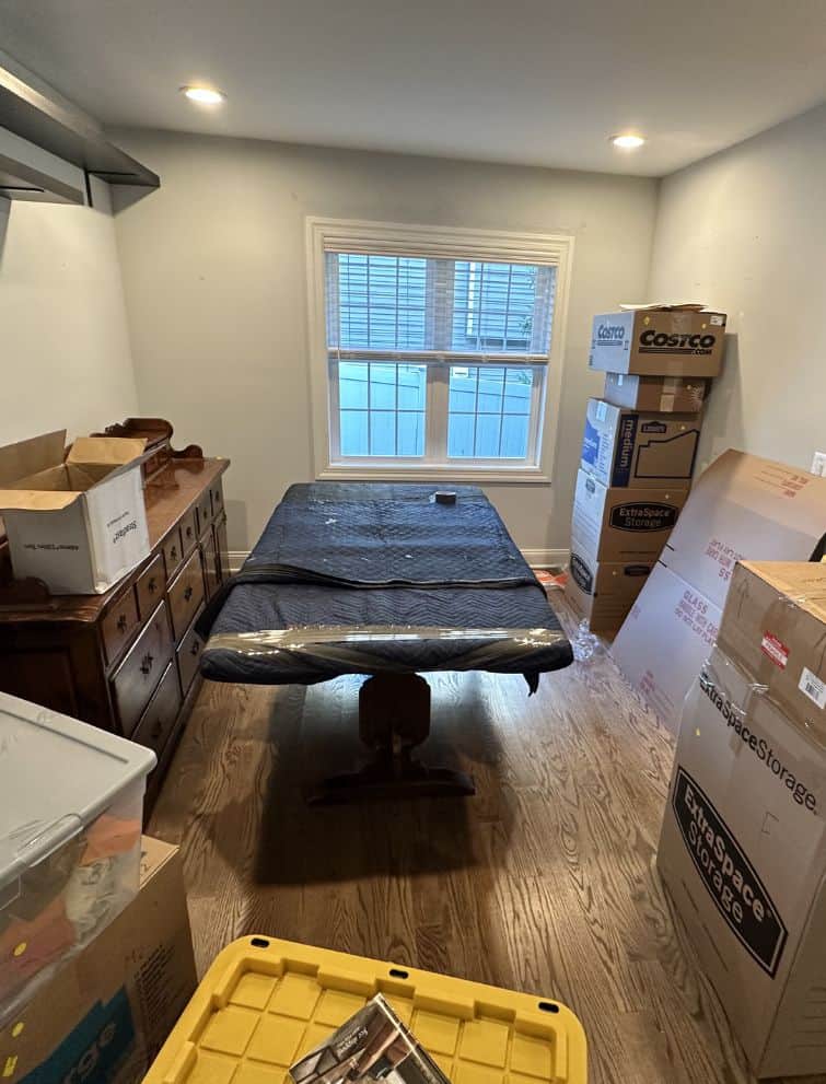 Moving room with packed boxes and furniture for US relocation.